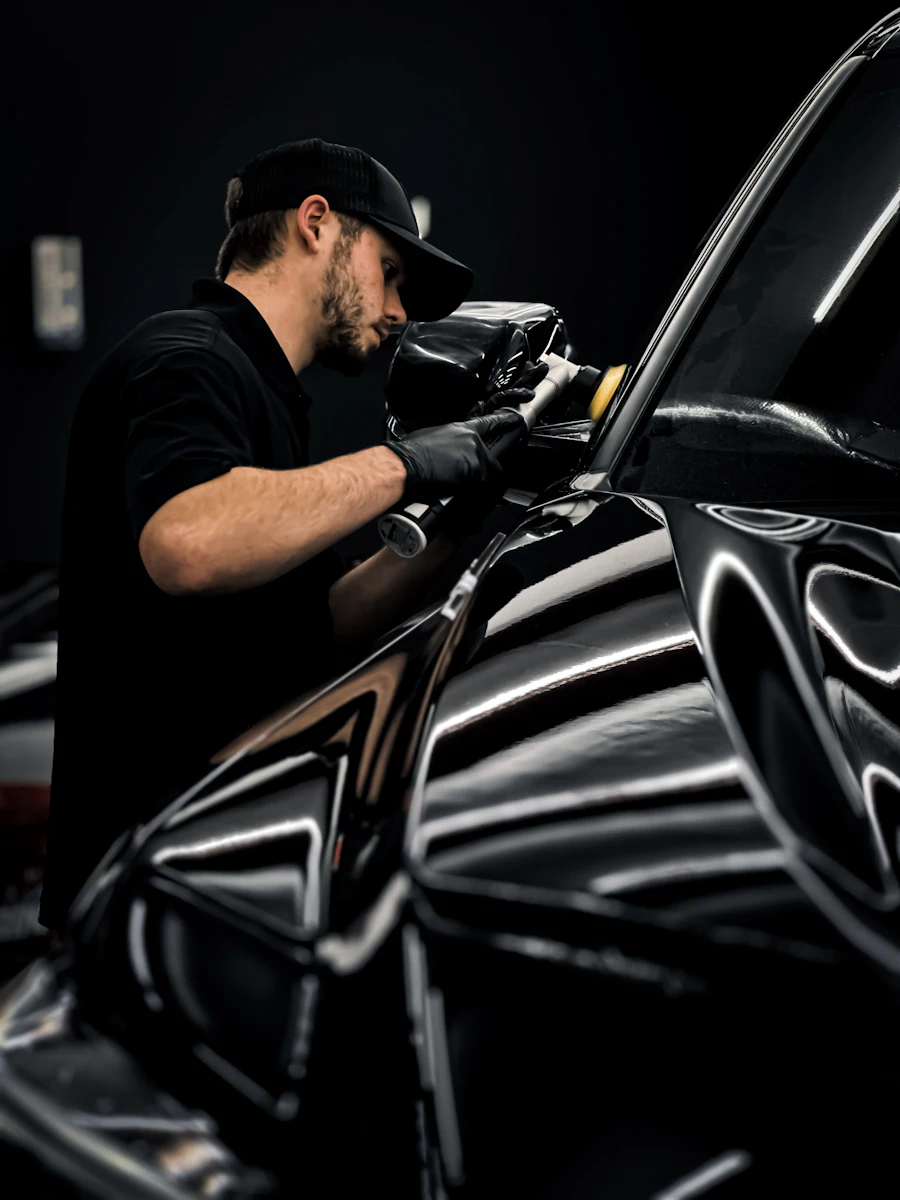 Detailer puliendo la carrocería de un auto negro